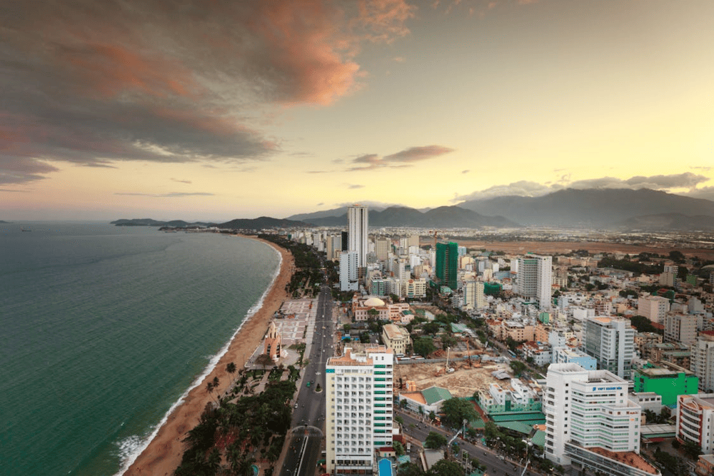 The Nha Trang Beachfront Promenade charms with blue waters, soft sands, and swaying coconut palms